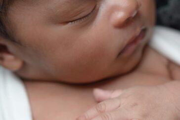 A close-up of a peaceful newborn baby sleeping wrapped in a soft blanket.